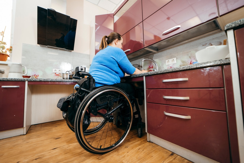 Une cuisine adaptée PMR avec une femme